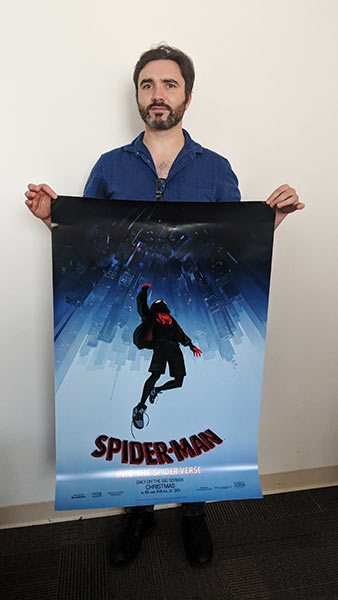 Ultan Courtney holds Spider-man Into the Spider Verse sign