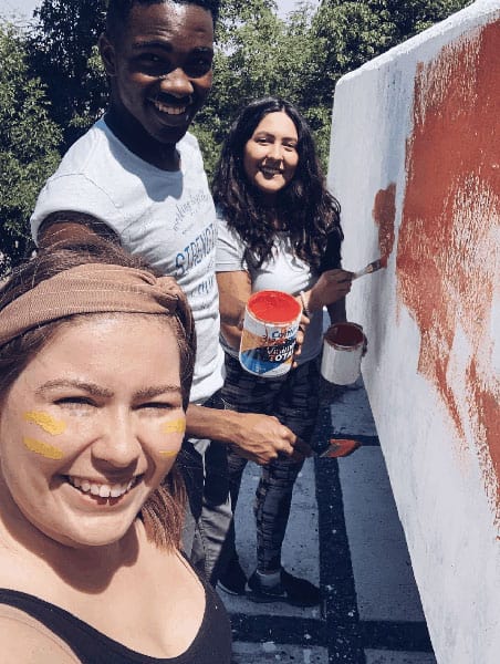 Volunteer abroad students in Up with People painting a mural